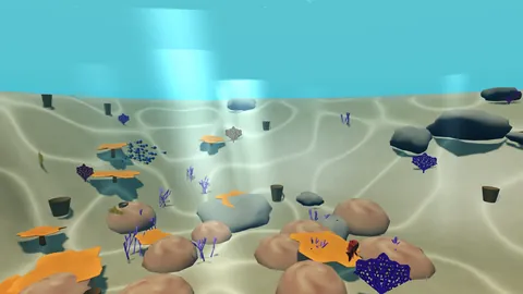 A sunlit reef underwater: sand, coral and a shoal of small blue fish.